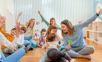 Eltern, die am Musikunterricht in einem Kindergarten teilnehmen. Lehrerin und Eltern arbeiten zusammen. Partnerschaft zwischen Vorschule und Eltern.